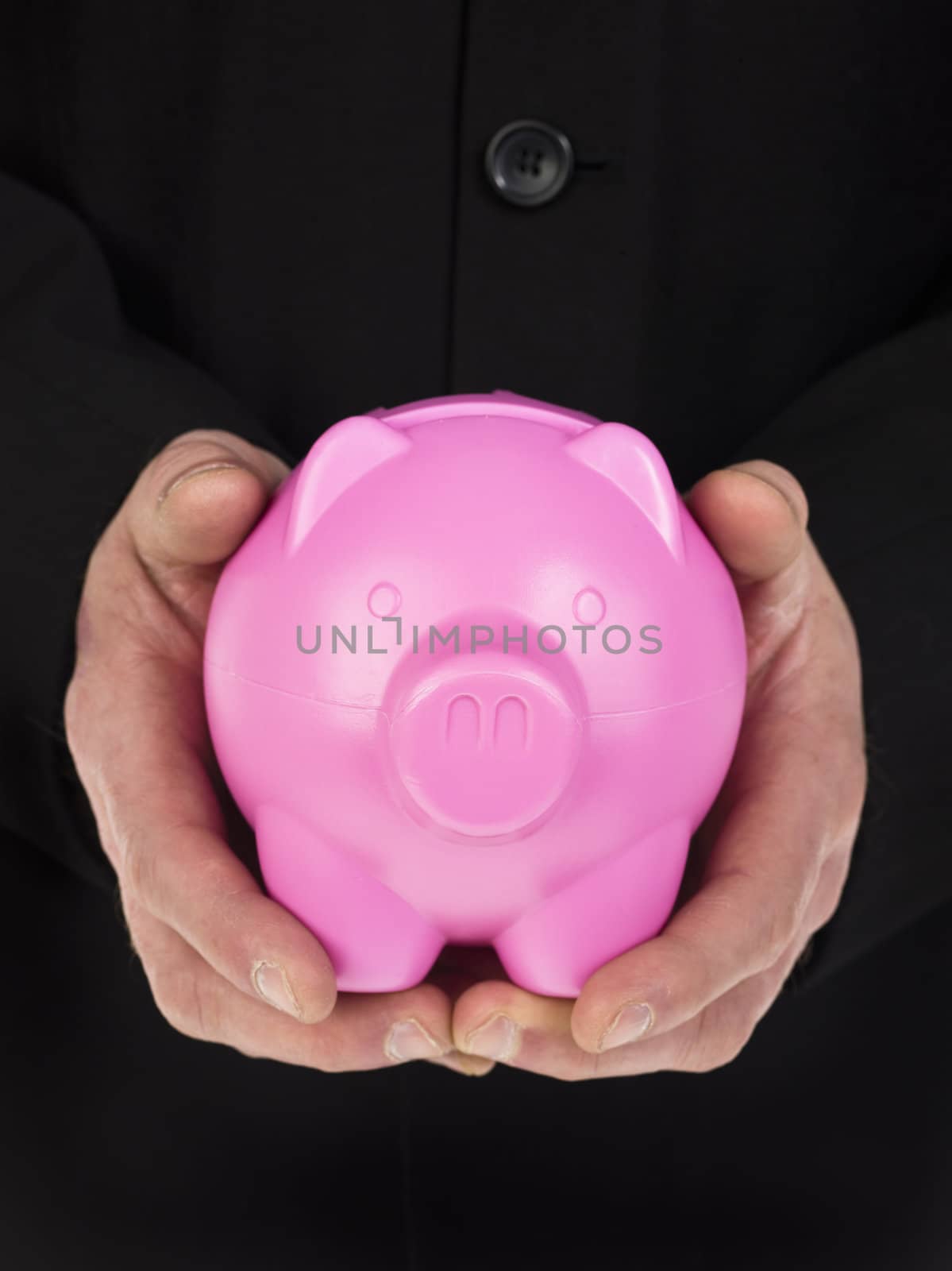 Close-up cropped image of a mans hand holding a pink piggy bank 