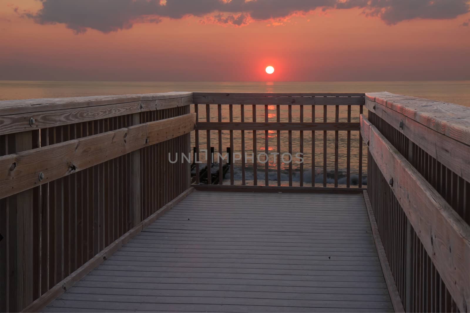 The sun is just above the horizon over the Atlantic ocean in early morning at a public beach access in Nags Head, North Carolina
