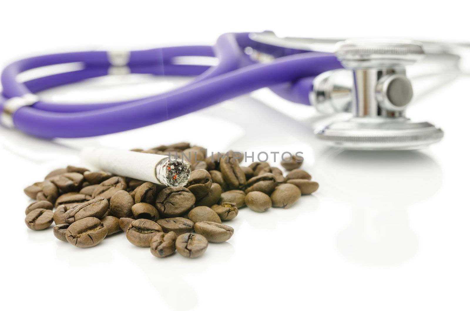Cigarette on coffee beans with stethoscope in background. Addiction concept.