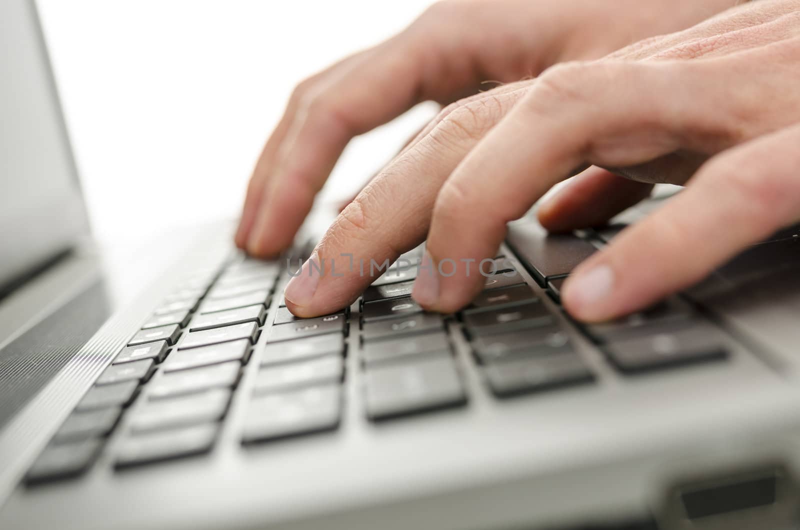 Closeup of businessman hands typing on laptop keyboard.