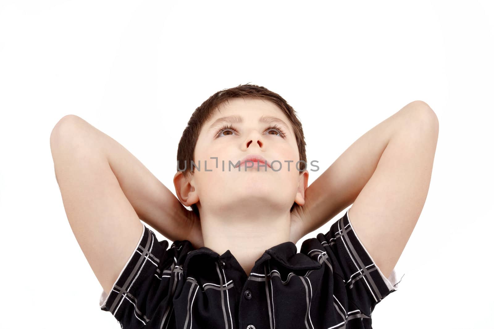 Portrait of boy on white background, smiling, he looks up with his hands behind his head. 