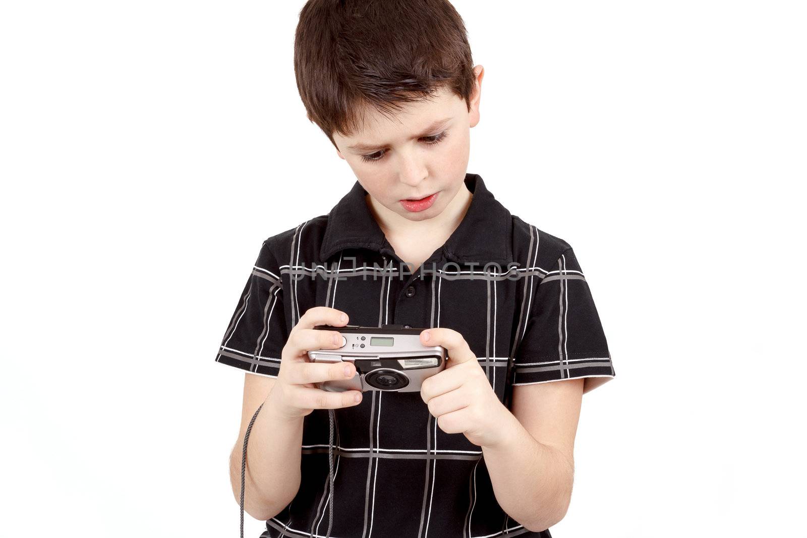 small boy checking analog camera settings on white background