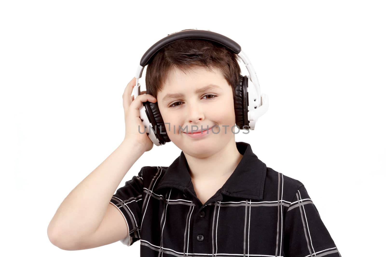 Portrait of a happy smiling young boy listening to music on headphones against white background 