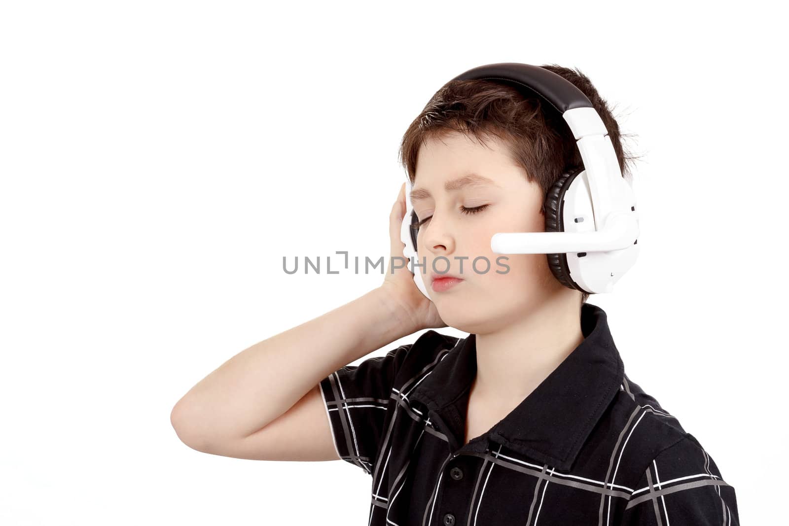 Portrait of a happy young boy listening to music on headphones against white background 