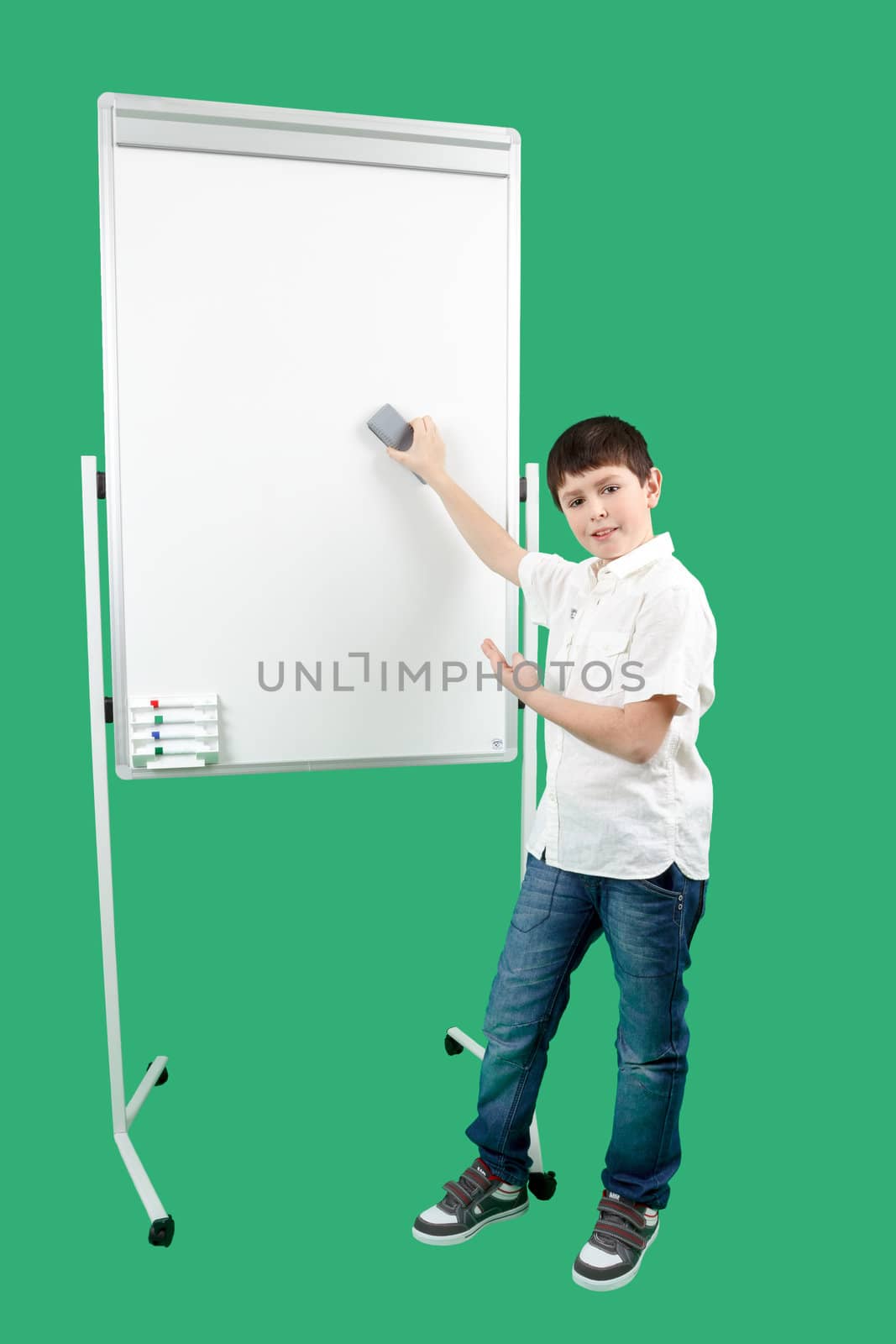 Portrait of happy little boy showing white blank board on green background