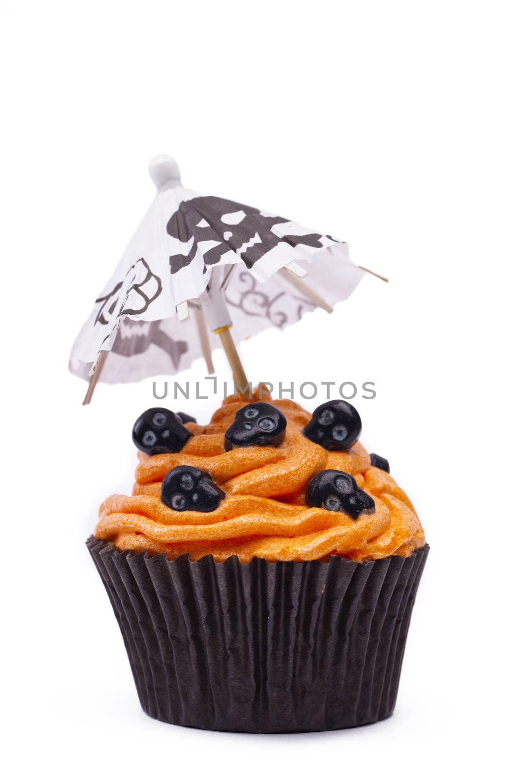 Close-up image of a orange cupcake with skull topping and canopy with skull design over white background.