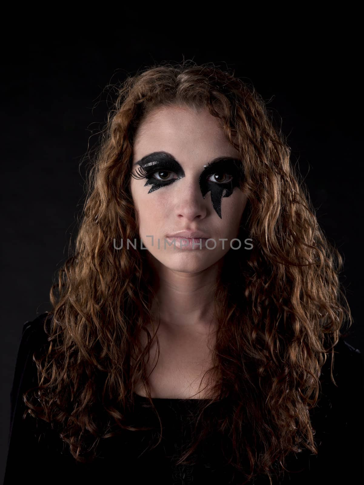 A portrait of a witch as she stars into the camera.