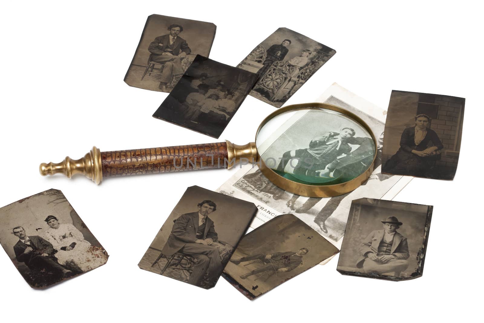 A magnifying glass on top of some ancient photographs