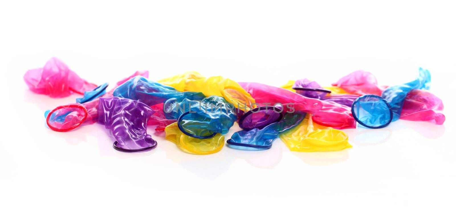 Image of used colorful condoms on a white background