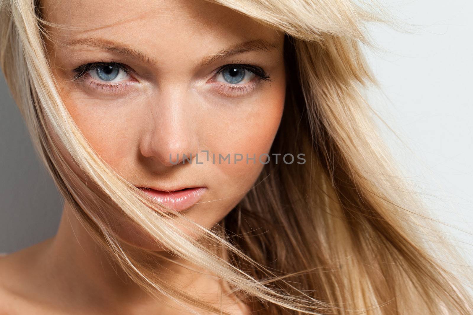 Young attractive woman posing over grey background