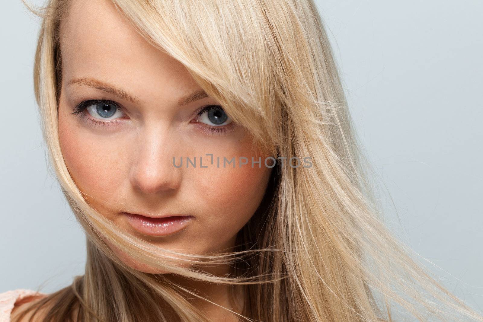 Young attractive woman posing over grey background