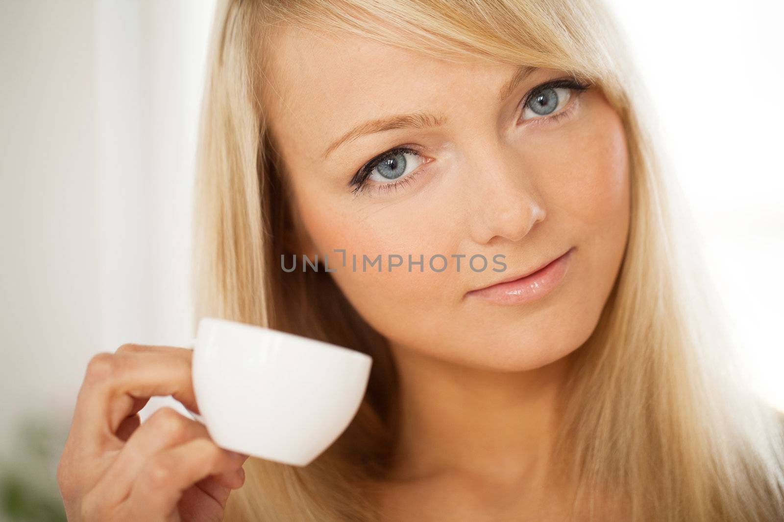 Closeup portrait of young attractive woman with cup