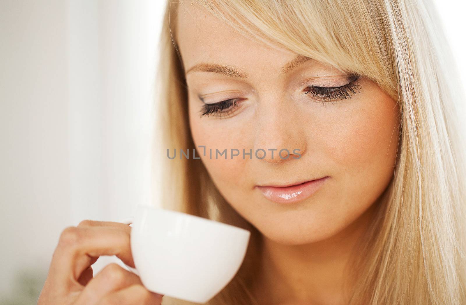 Closeup portrait of young attractive woman with cup