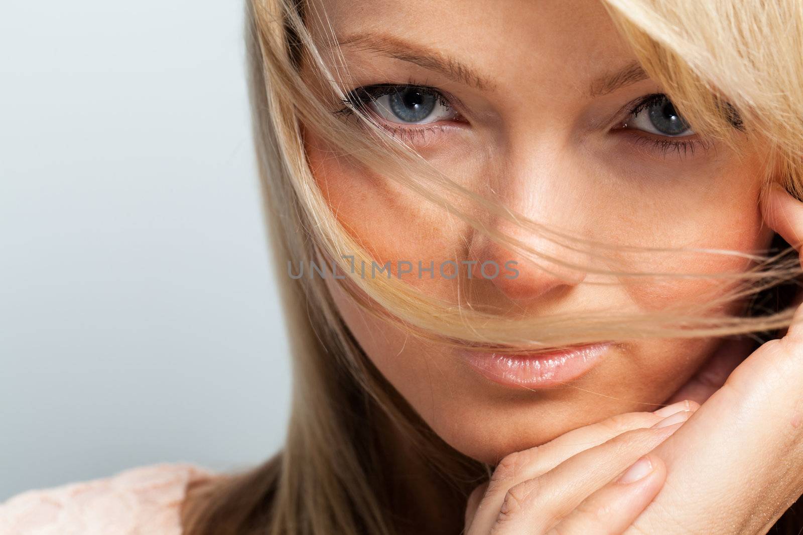 Young attractive woman posing over grey background