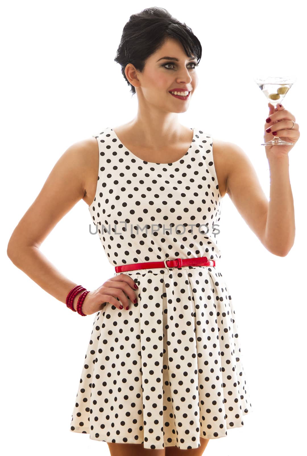 young woman with retro look holding a martini drink in the motion of a toast