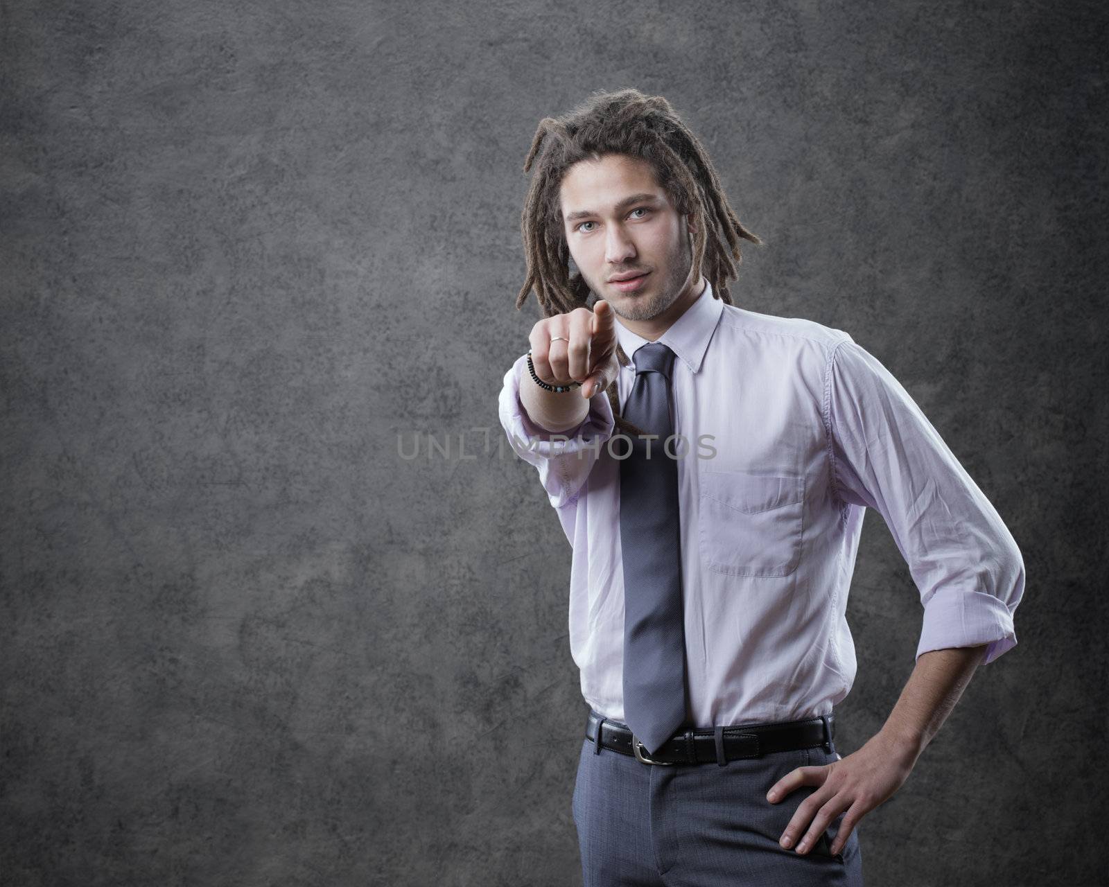 Young business man in suite, pointing at camera
