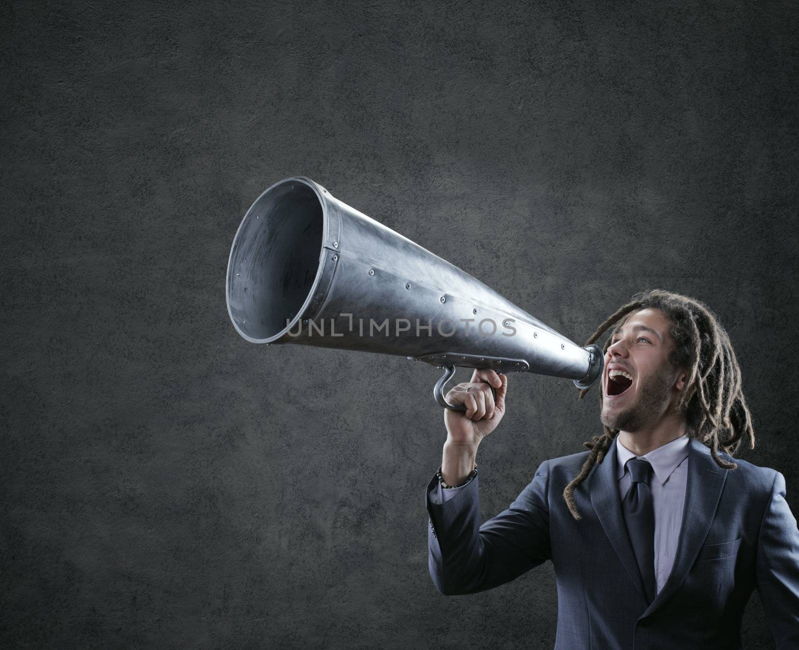 Young businessman yelling trough a vintage megaphone