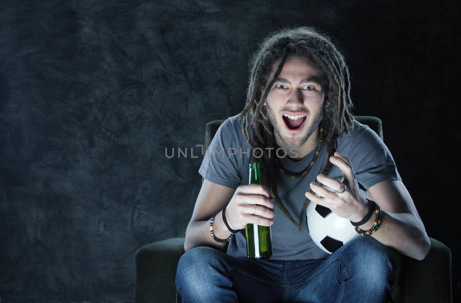 Young adult man watching football on television: Goal!