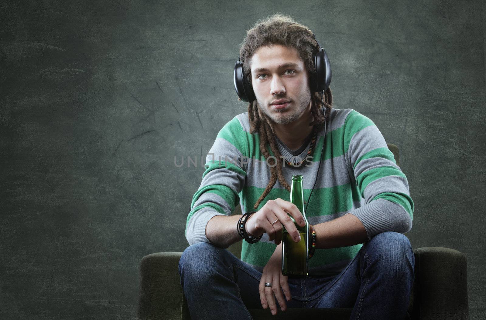 Relaxed young guy listening to music with headphones