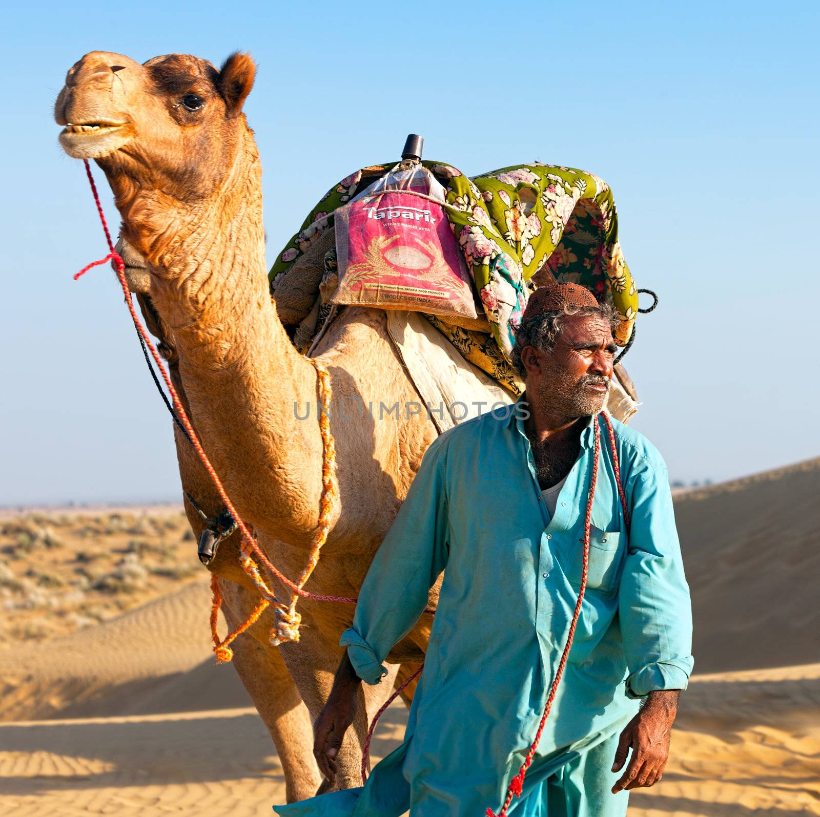 Camel man leads his camel across the Thar desert  by vladimir_sklyarov