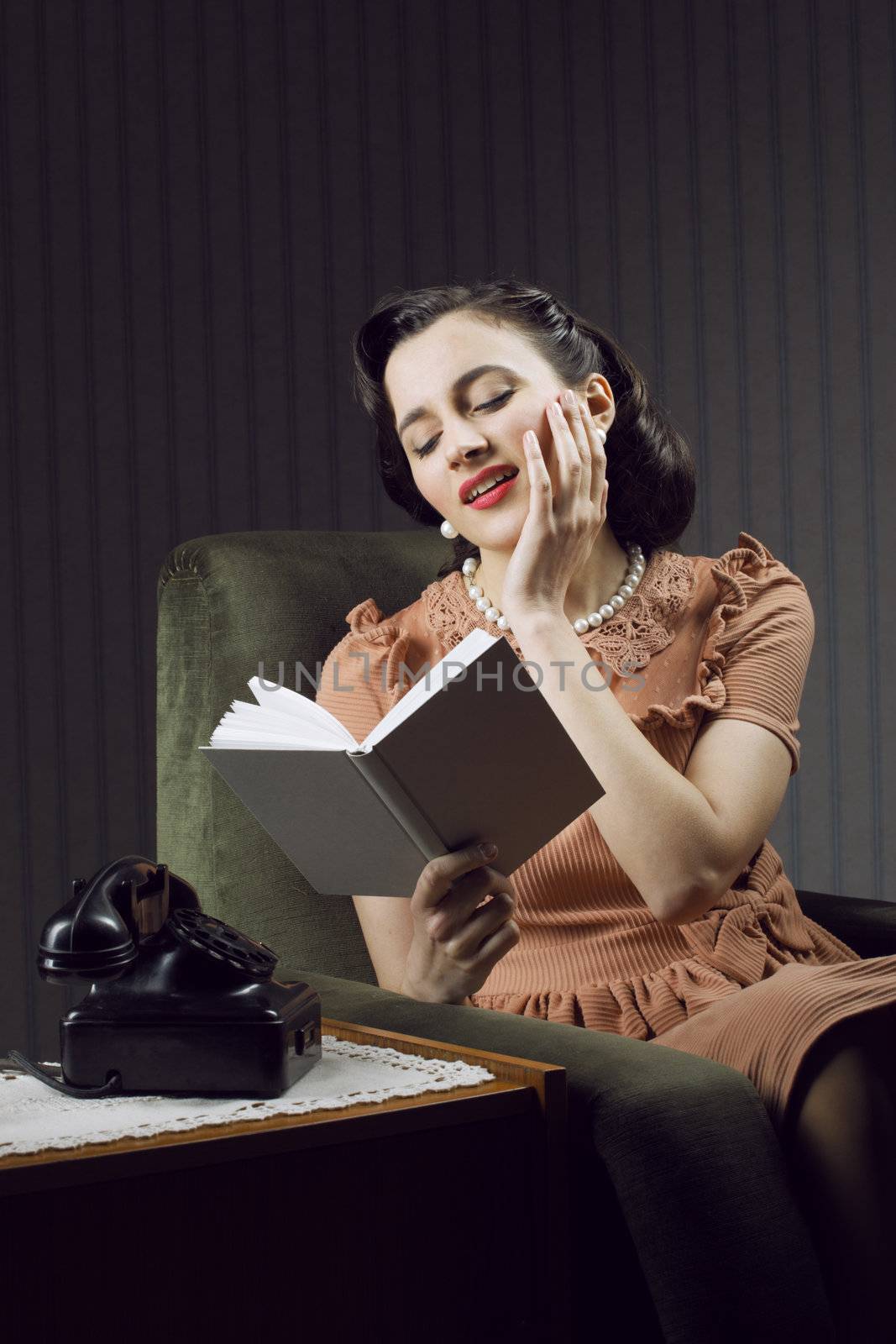 Young woman daydreaming while reading a textbook