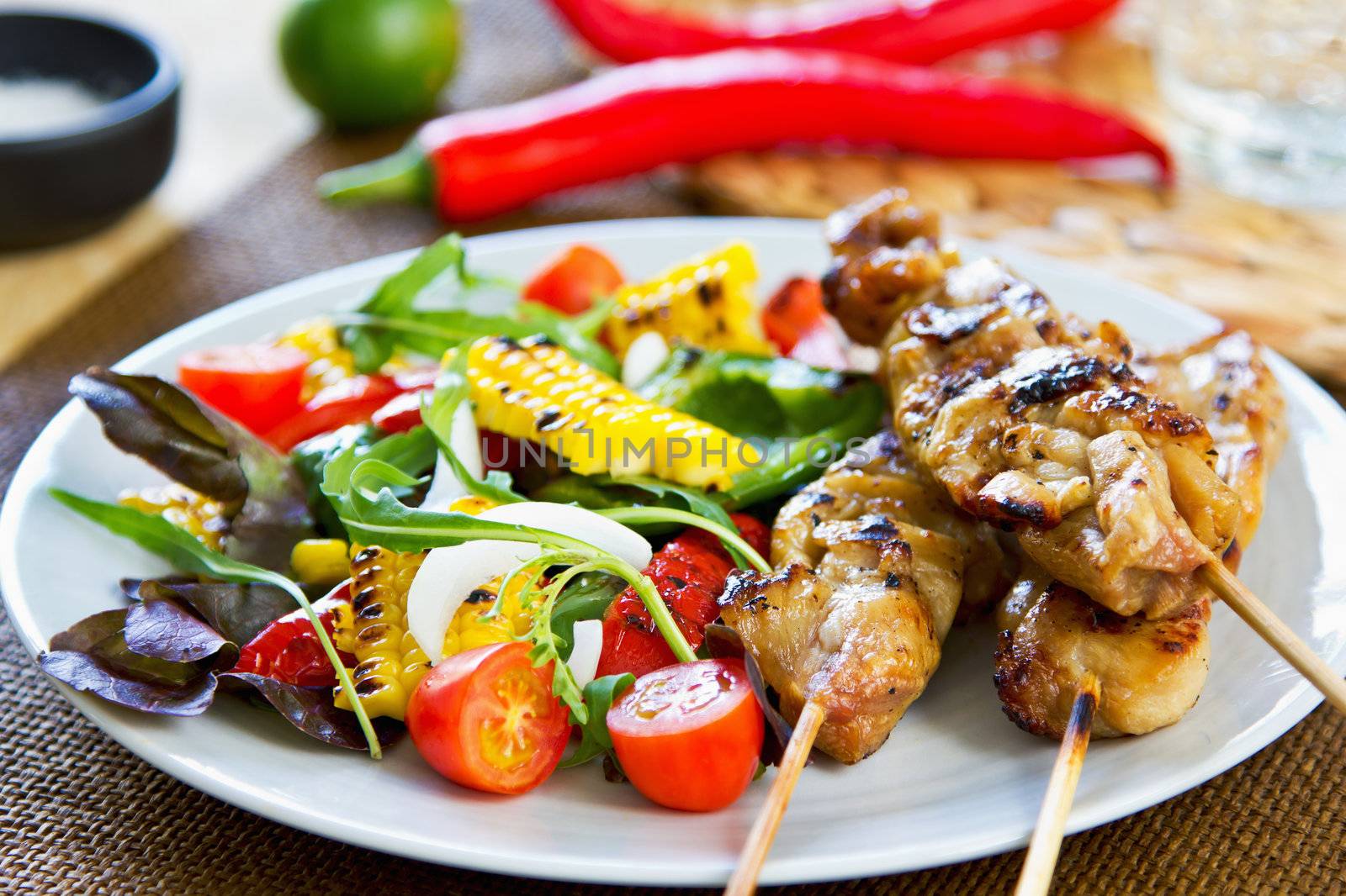 Grilled chicken skewer with salad by vanillaechoes