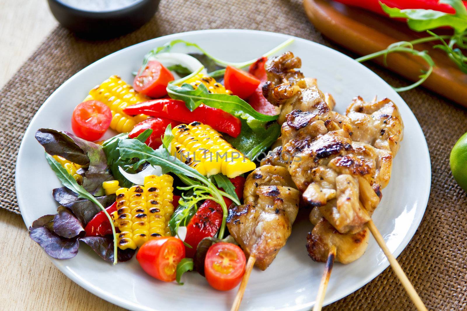 Grilled chicken skewer with salad by vanillaechoes