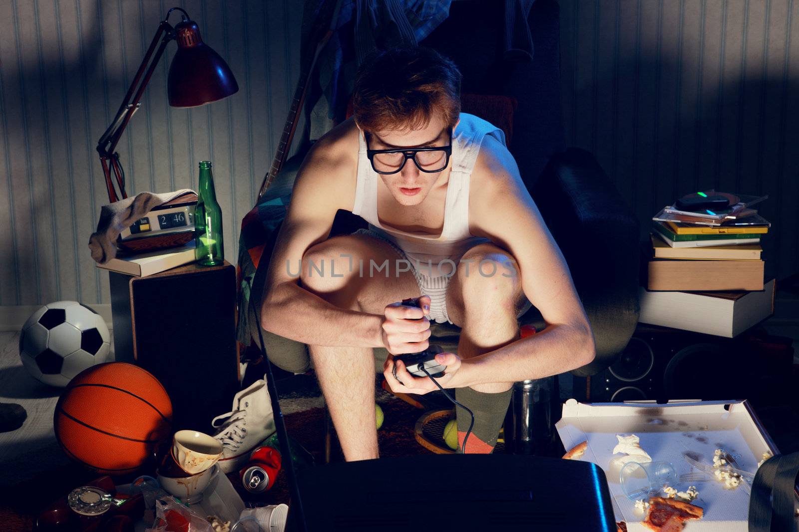 A teenager plays Video console games on his television