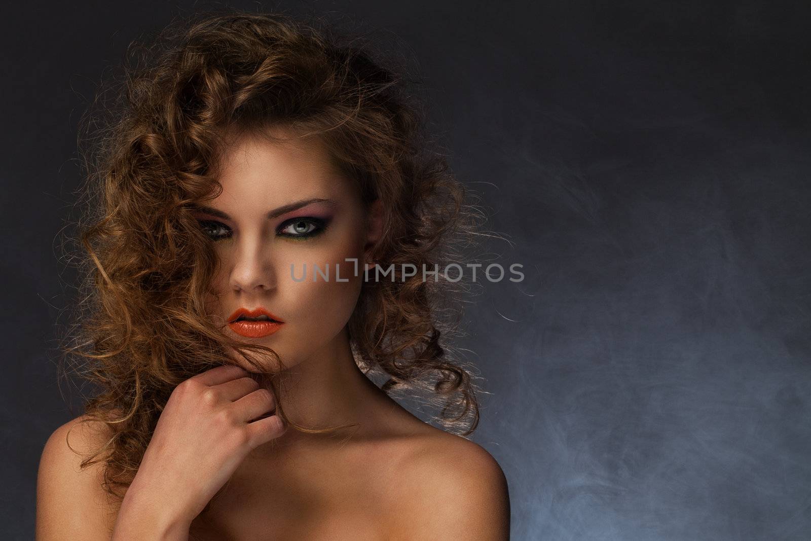 Beautiful caucasian woman with curls and evening makeup