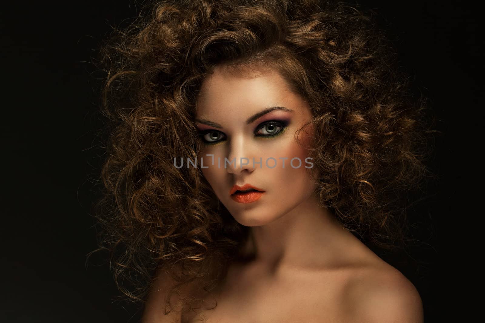 Beautiful caucasian woman with curls and evening makeup