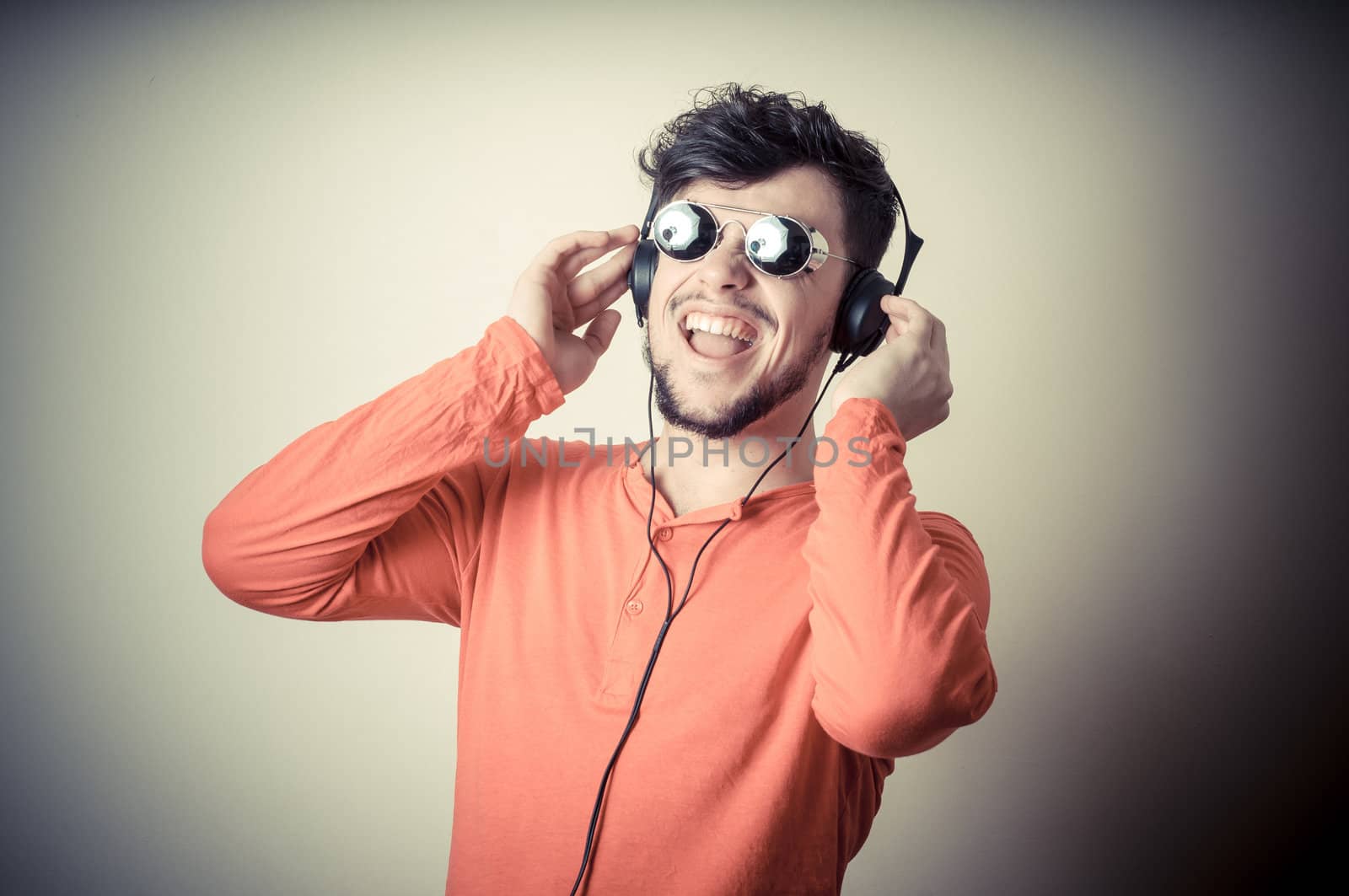 Stylish man listening to music on vignetting background