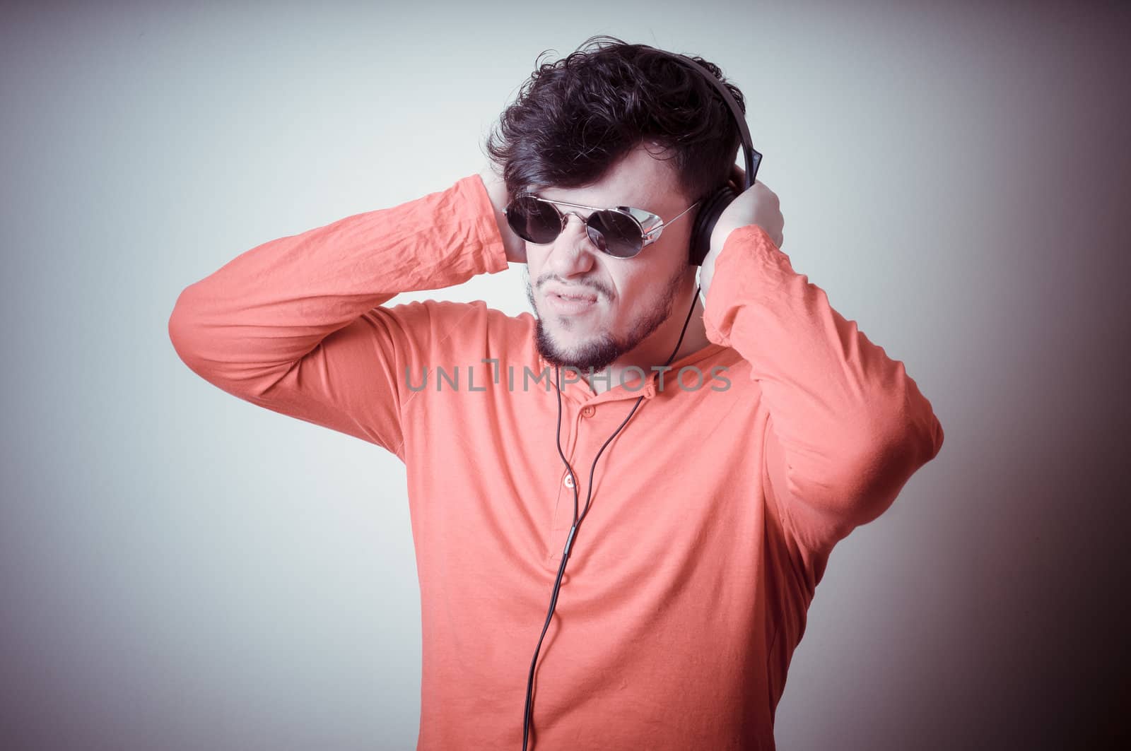 Stylish man listening to music on vignetting background