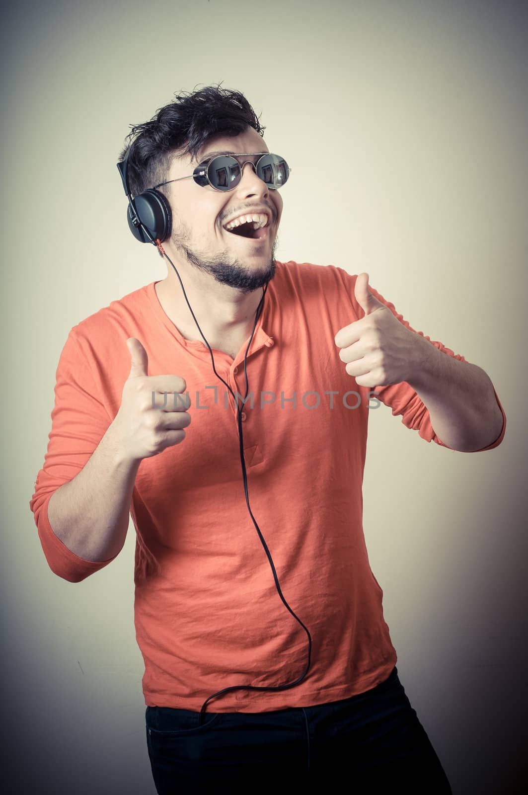 Stylish man listening to music on vignetting background