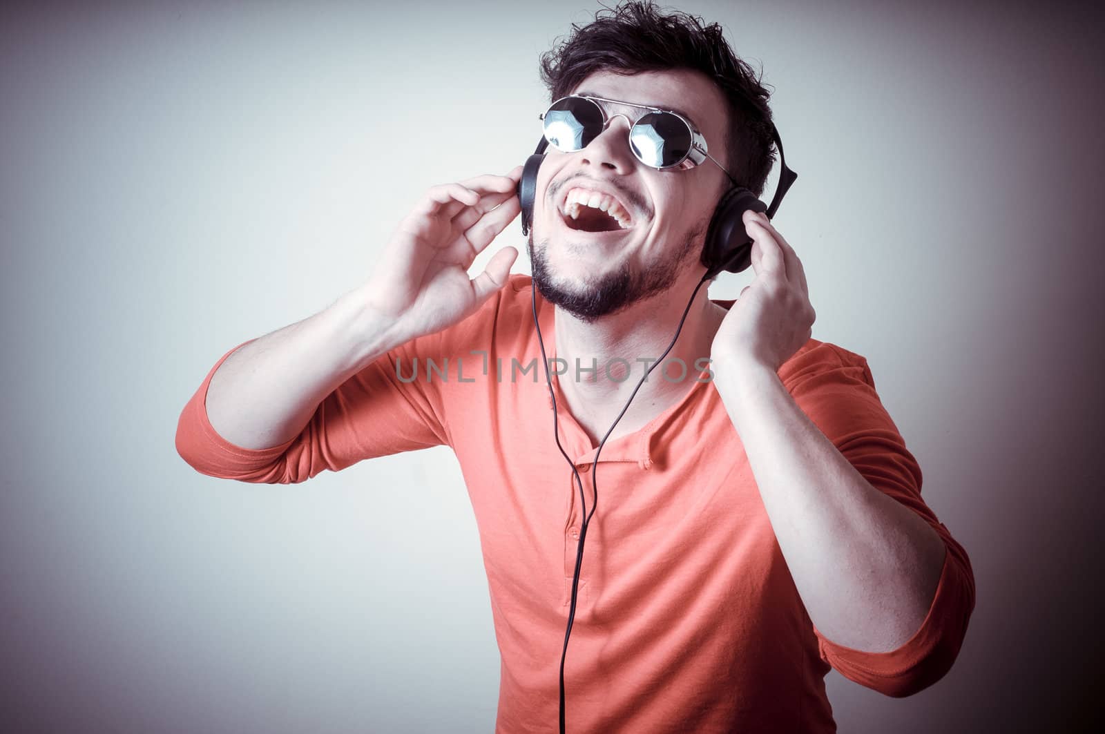 Stylish man listening to music on vignetting background