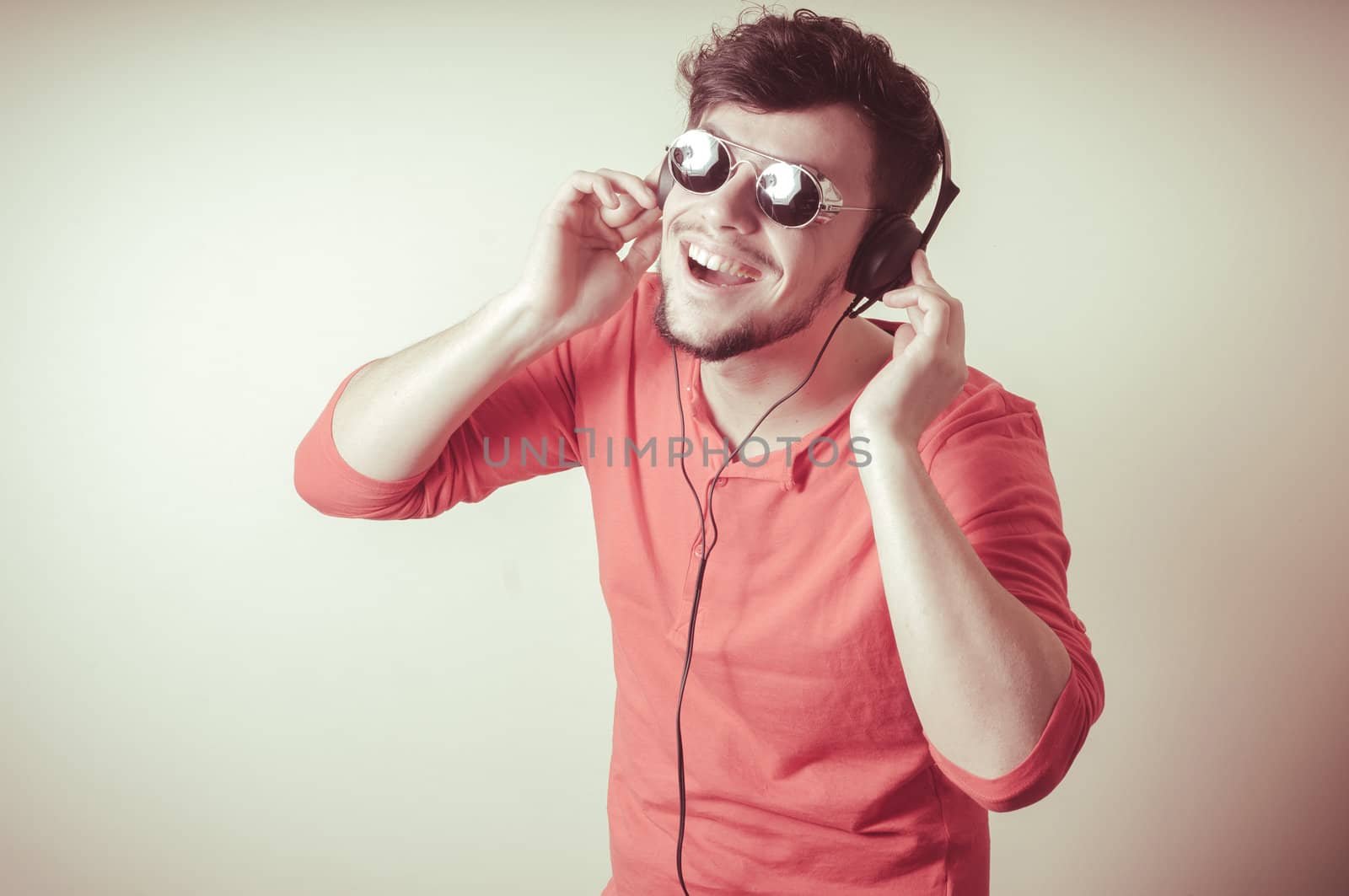 Stylish man listening to music on vignetting background