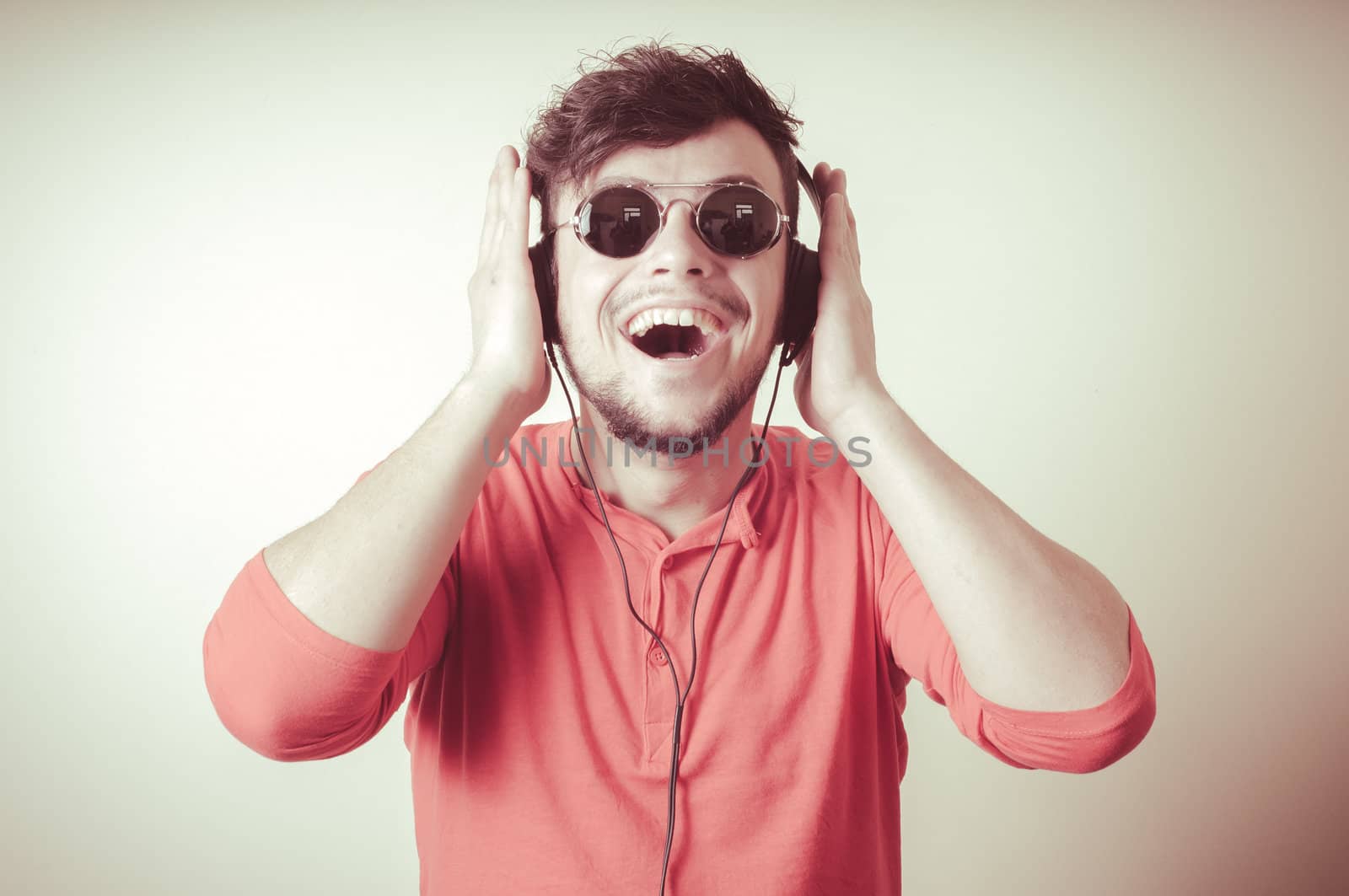 Stylish man listening to music on vignetting background