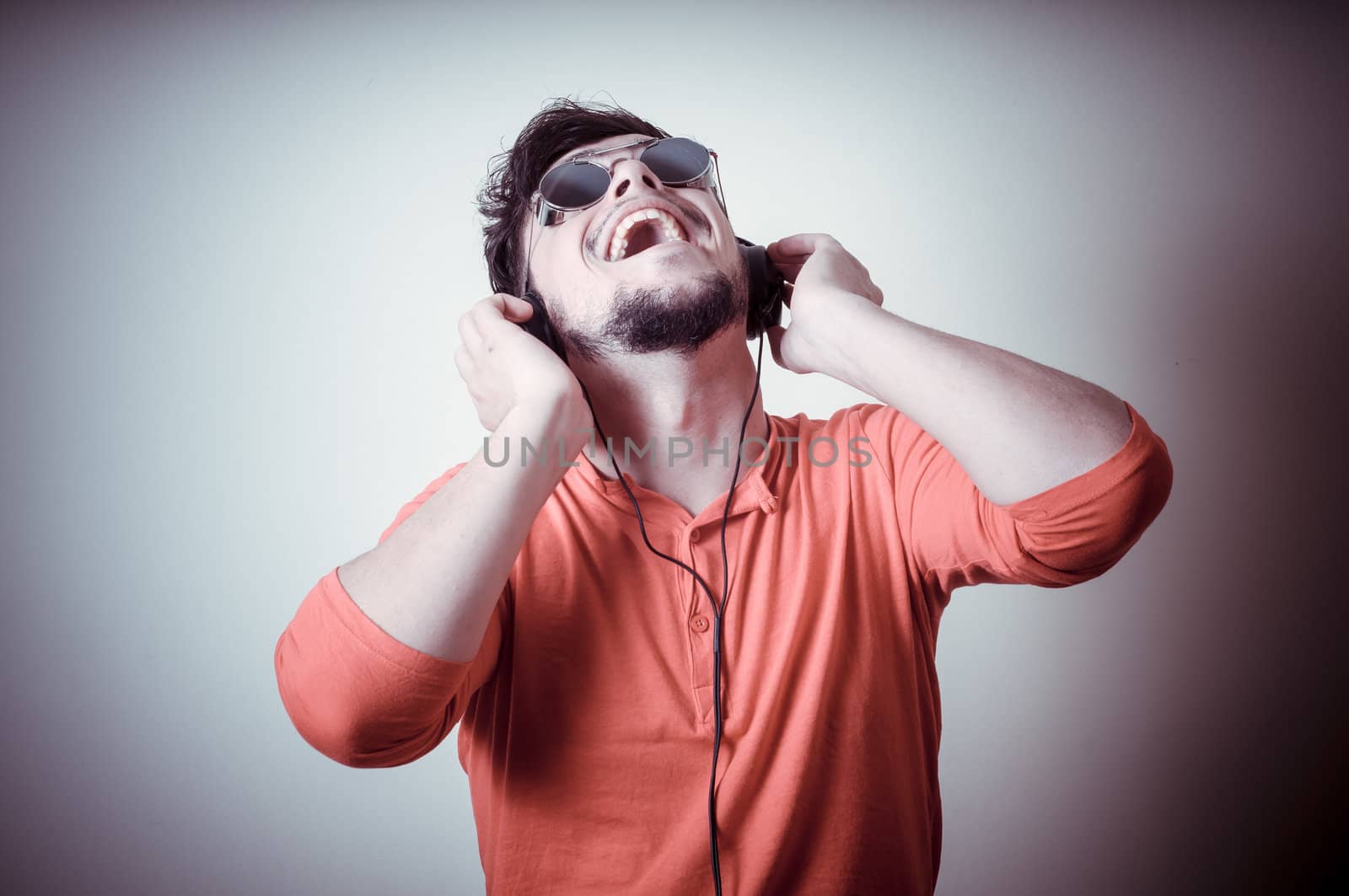 Stylish man listening to music on vignetting background