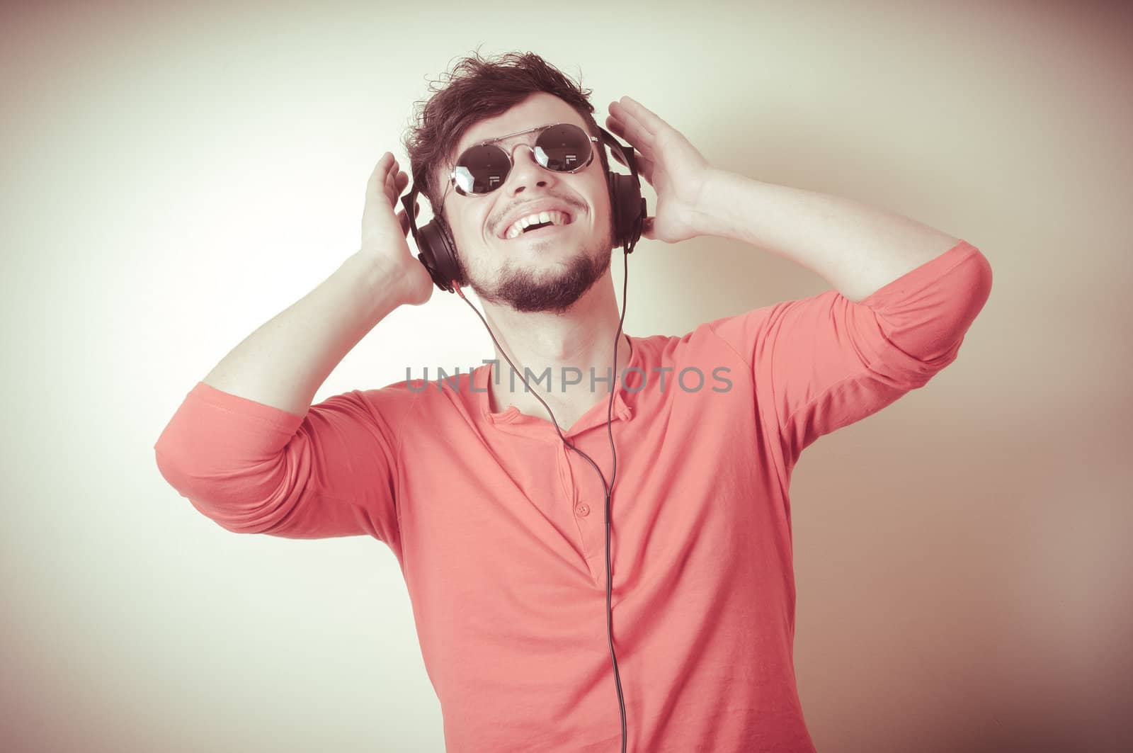 Stylish man listening to music on vignetting background