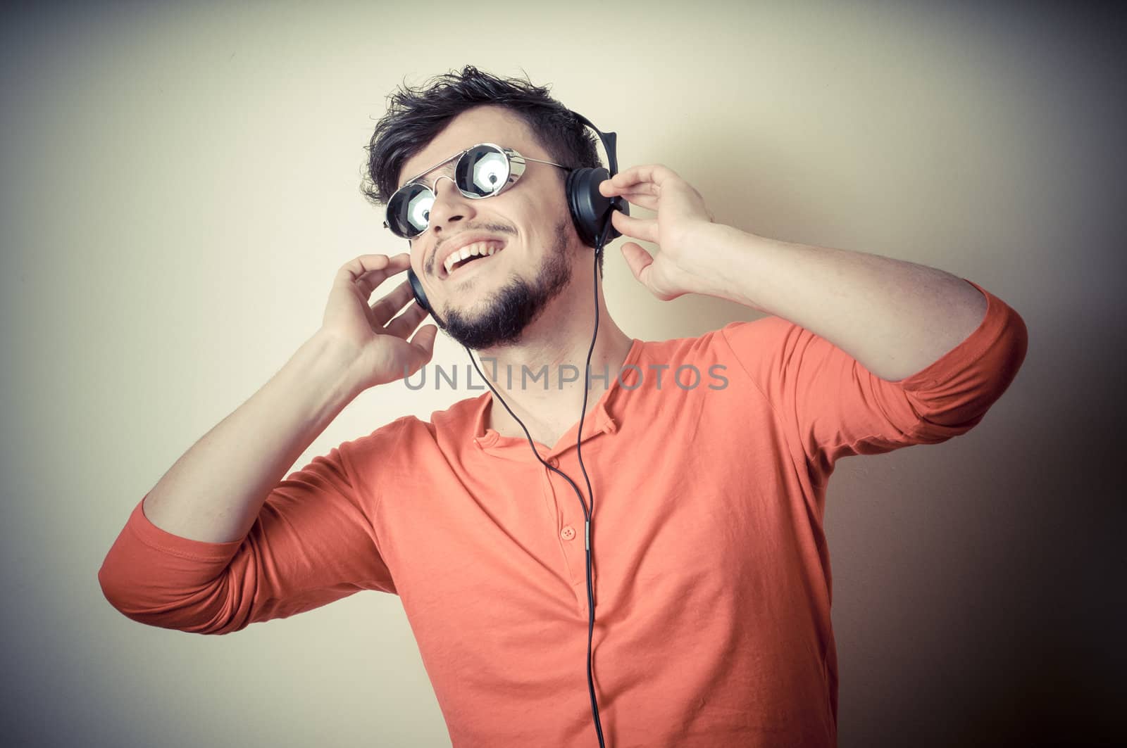 Stylish man listening to music on vignetting background