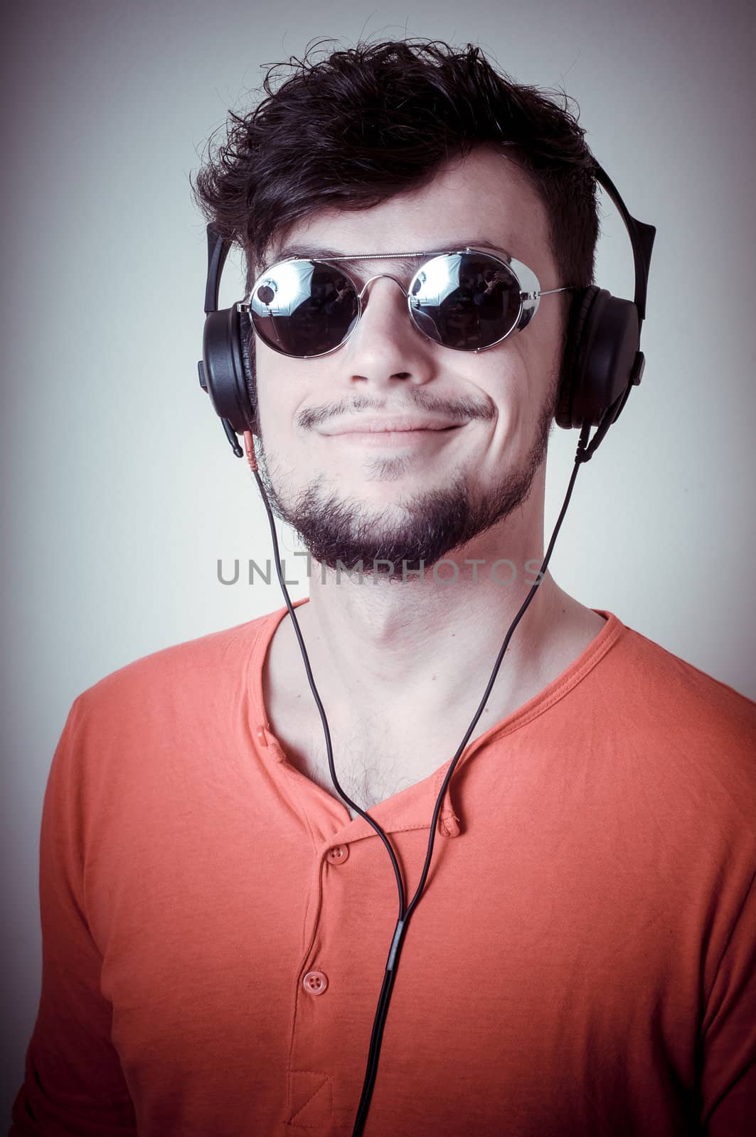 Stylish man listening to music on vignetting background