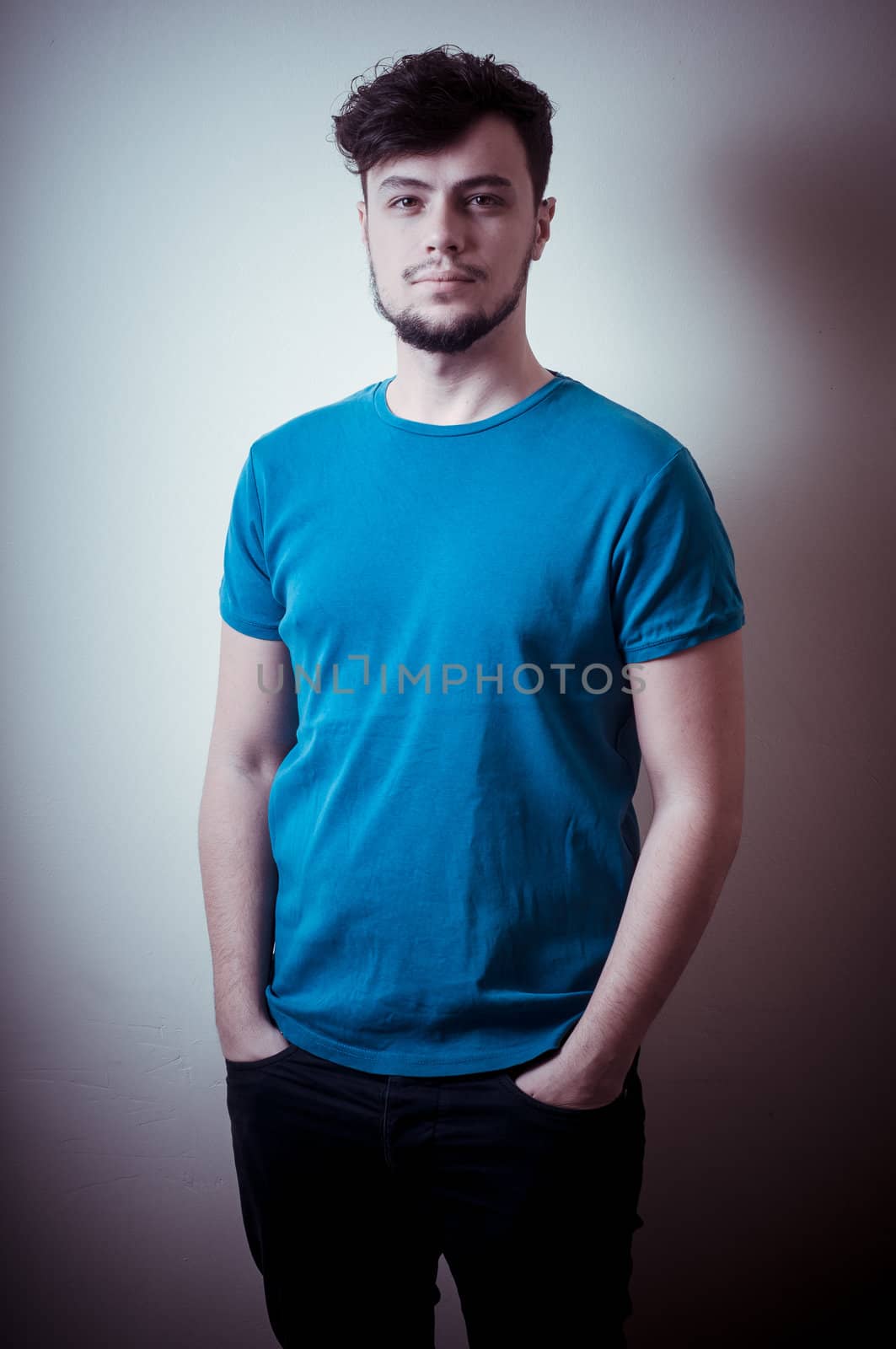 portrait of stylish young man with blue shirt on vignetting background