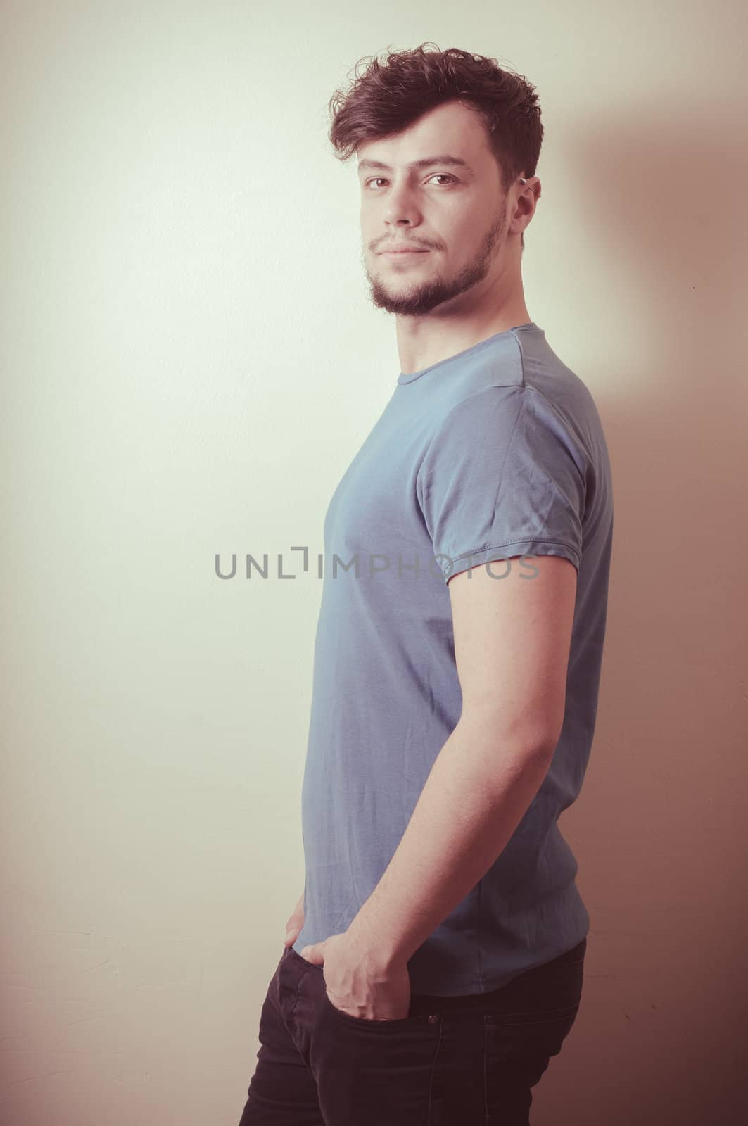 portrait of stylish young man with blue shirt on vignetting background