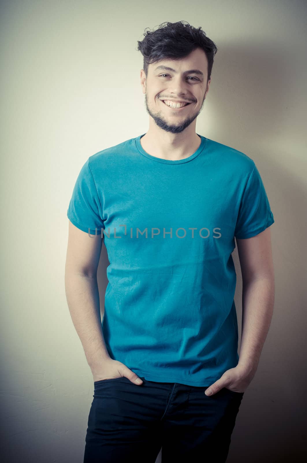 portrait of stylish young man with blue shirt on vignetting background