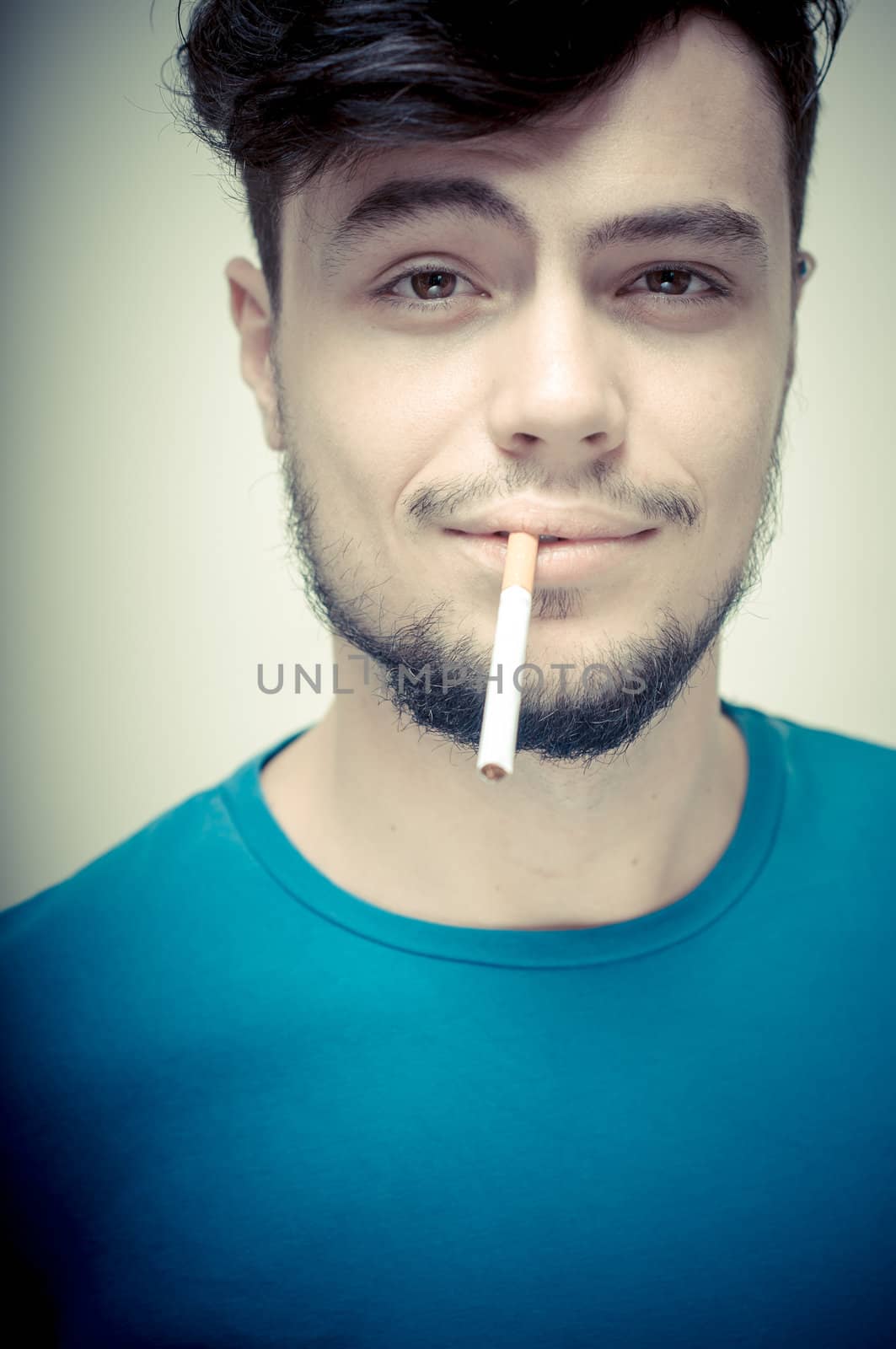 stylish young modern man with cigarette on vignetting background
