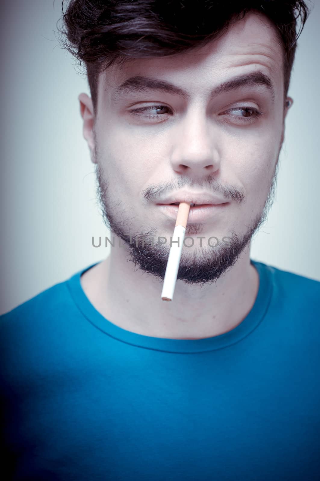 stylish young modern man with cigarette on vignetting background