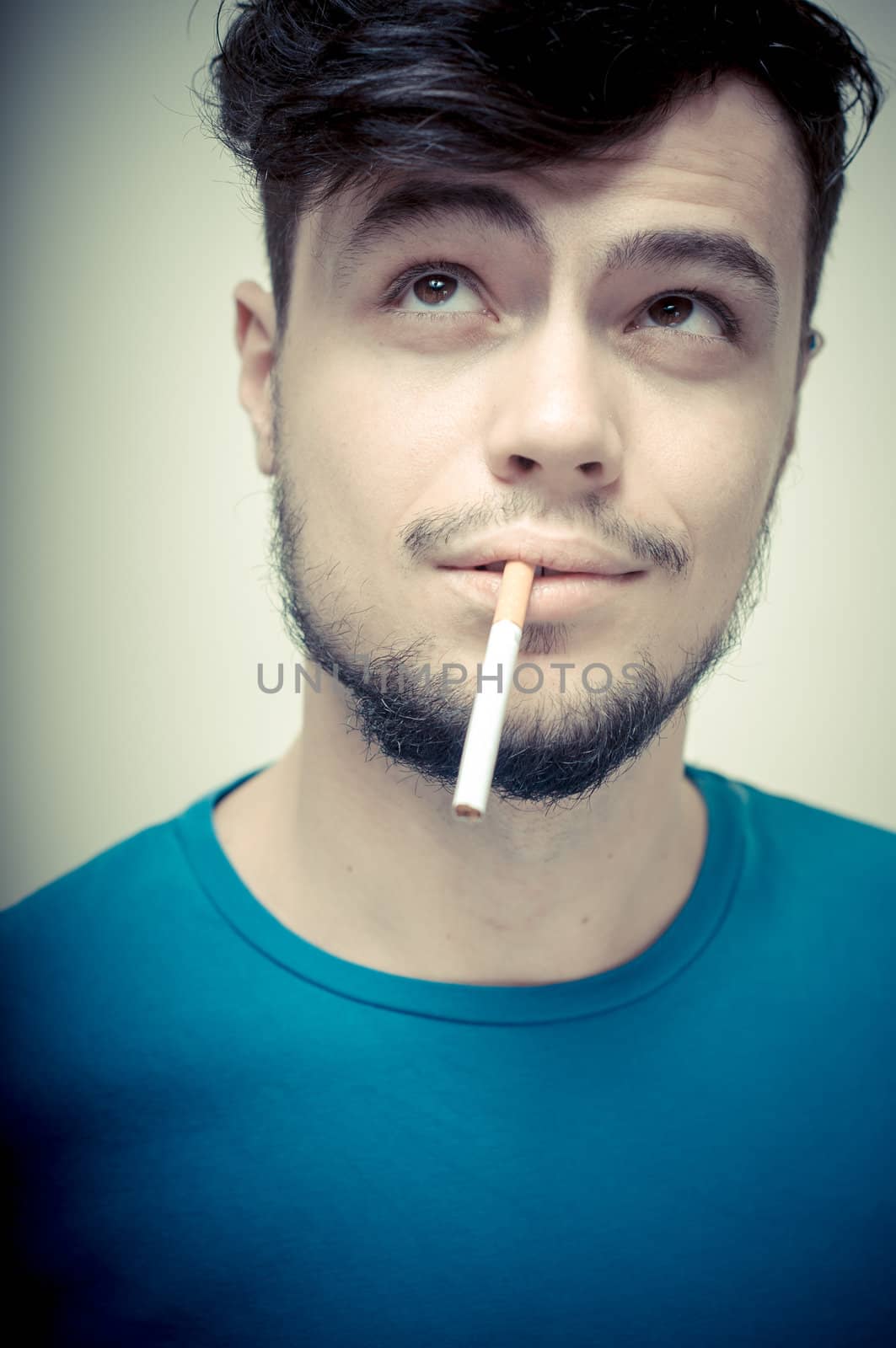 stylish young modern man with cigarette on vignetting background