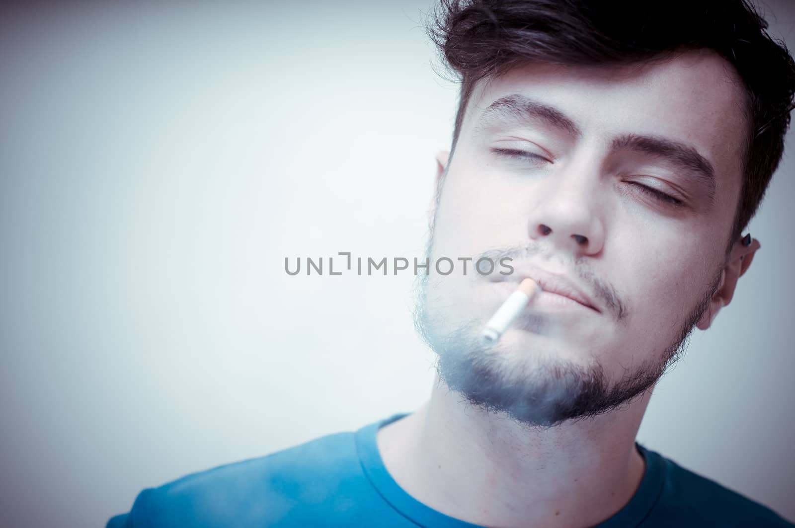 stylish young modern man with cigarette on vignetting background