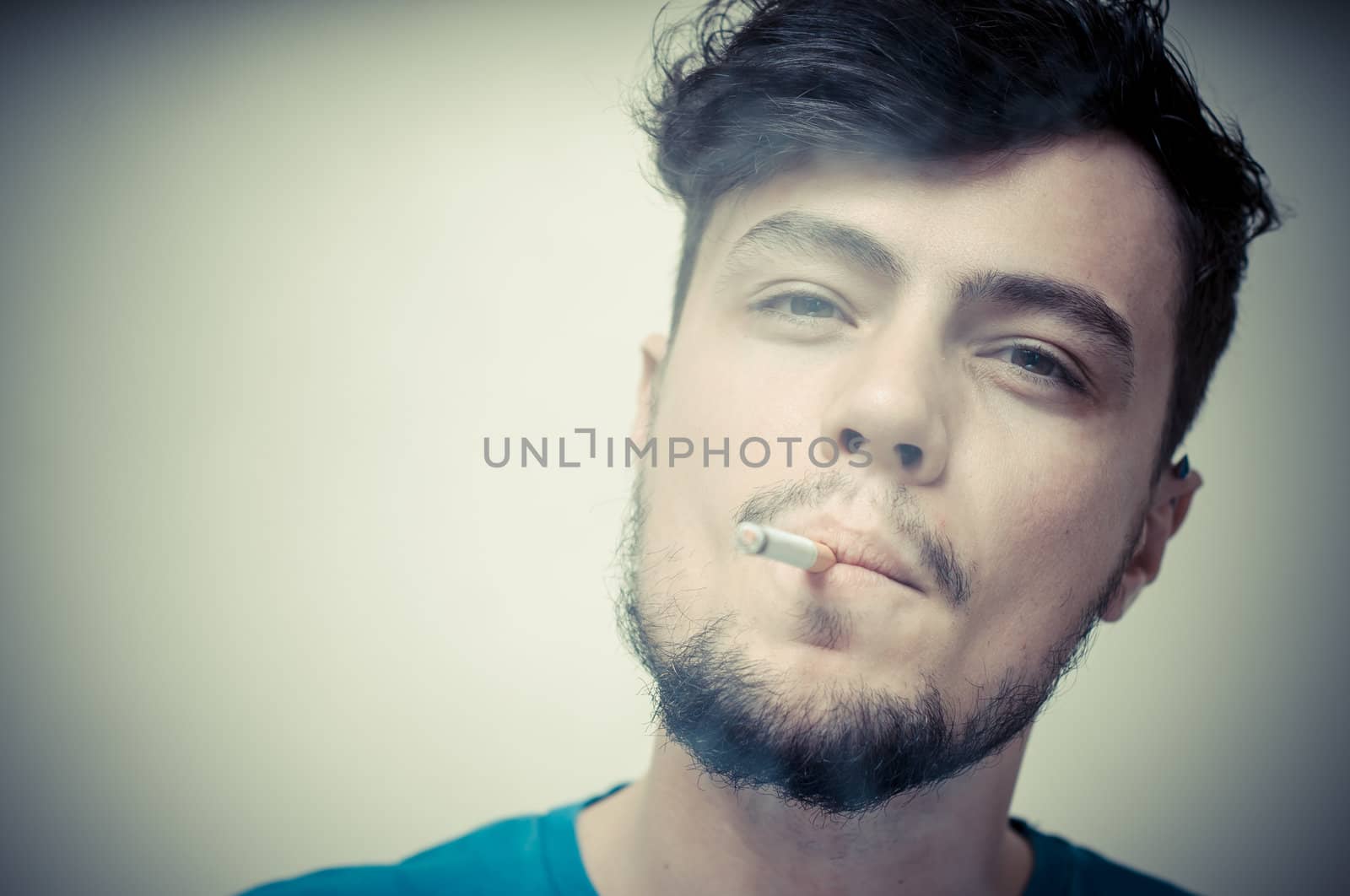 stylish young modern man with cigarette on vignetting background