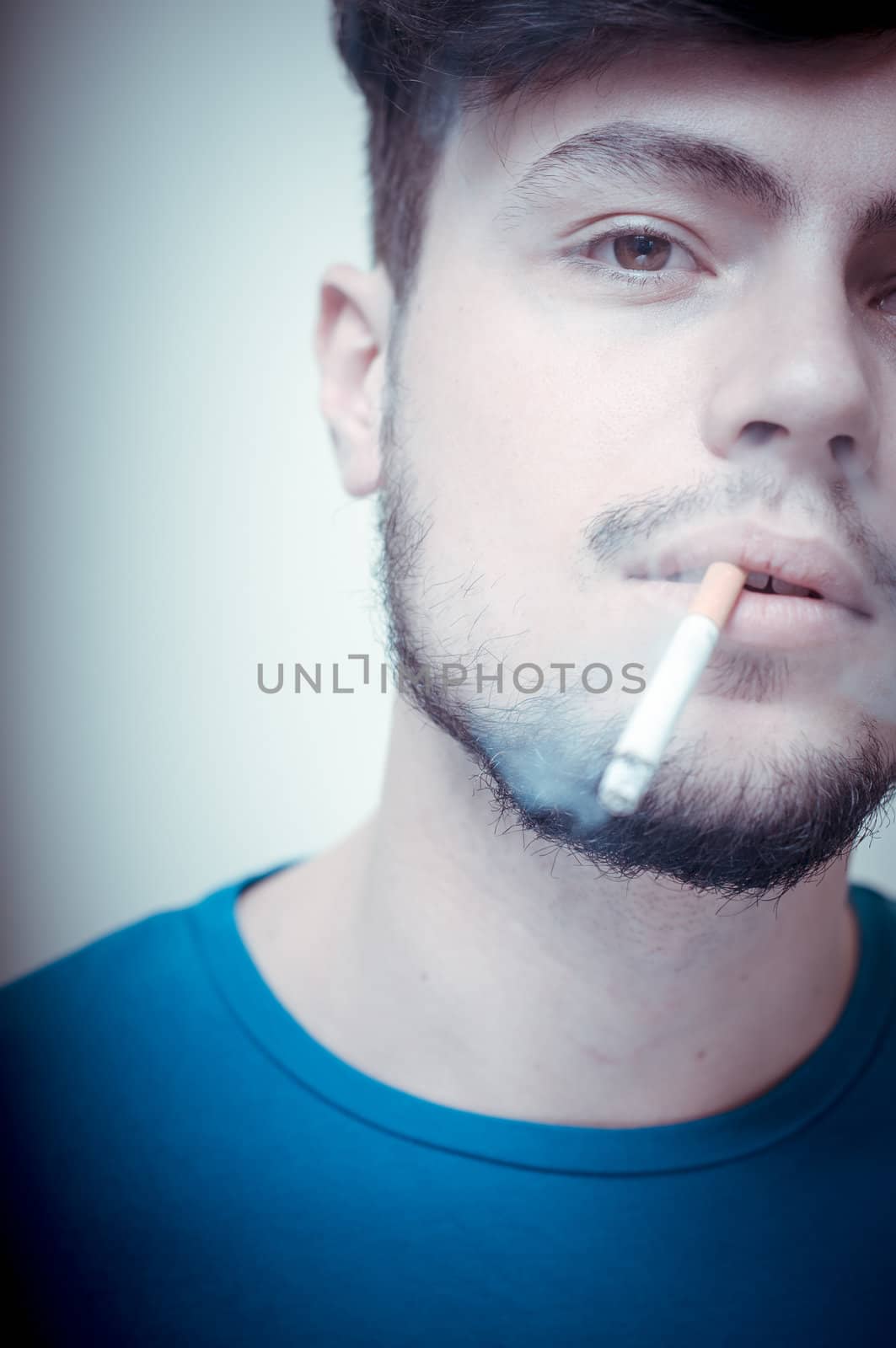 stylish young modern man with cigarette on vignetting background