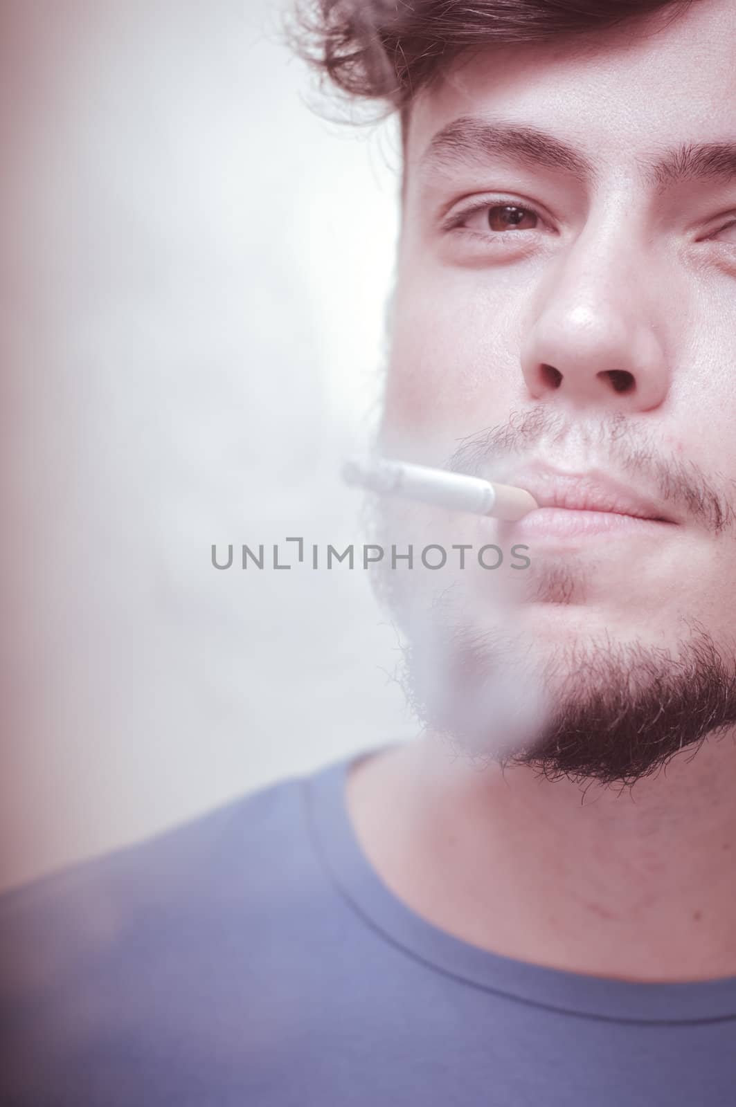 stylish young modern man with cigarette on vignetting background